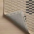 Rug corner flipped over revealing branded edge with Chris Loves Julia x Loloi logo on backing