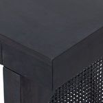 Close-up of arched cane woven panel on leg of Tilda black wash mango wood desk
