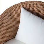 Side close-up of white back cushion resting against woven wicker barrel back