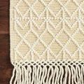 Corner of Noelle Ivory Gold Rug on dark wood floor highlighting raised diamond texture and fringe