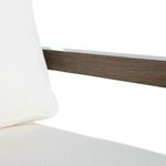 Close-up of white cushion and oak frame armrest showing fabric texture