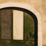 Close-up crop on textured green and white panels of the arched door showing surface detail and wear