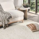 Jute handwoven rug styled in living room with light wood and natural decor accents