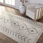 Taos Tribal rug styled in bright room with white armchair and large neutral vase