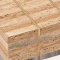 Close-up of corner showing travertine texture and brass inlay stripes running vertically