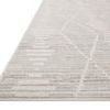 Close-up angled view showing low pile texture and detailed linear pattern of ivory and silver rug