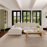 Berga sectional styled in living room with light rug, wooden coffee table, and large windows