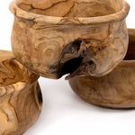 Side view focusing on a large hollow knot in the teak bowl with pronounced natural grain details