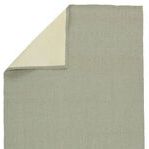 Top view showing corner of rug folded to reveal cream underside backing
