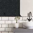 Wallpaper above white subway tile backsplash in bathroom, next to mirror and black faucet