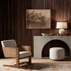Styled room view with console table, lamp, wooden bowl, armchair, and dark vertical wood slat wall