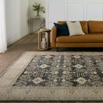 Pia Medallion navy and cream rug styled in front of caramel leather sofa with black and cream pillows