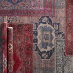 Monroe Medallion rug rolled next to other layered vintage style rugs in varying colors and patterns