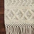Detailed close-up of Noelle rug’s fringe with raised tufted pattern on hardwood floor