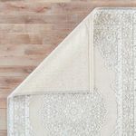 Rug corner flipped revealing solid light backing fabric and underside construction