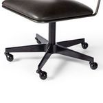 Close-up of five-star matte black iron swivel base and caster wheels