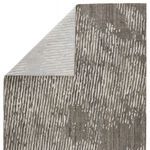 Backside corner folded over revealing woven underside and pattern reverse of rug