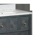 Corner close-up of marble countertop edge and rattan patterned drawer front with brass pulls