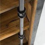 Close-up showing iron pipe support and reclaimed pine shelf from an angled perspective inside the Ivy Bookcase