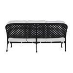 Back view of the sofa with tied white cushions resting on decorative black lattice frame