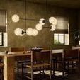 Room angle showing chandelier hanging over dining table with leather chairs and plants in background