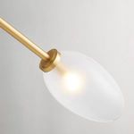 Close-up of a single frosted oval glass shade illuminating with aged brass mount