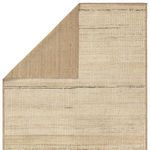 Back of rug folded over showing solid taupe underside contrasting front pattern