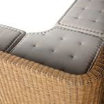 Corner detail showing rattan weave and cushion overlap on the bent seat angle