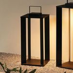 Hanley lantern lit at night on gravel surface beside similar large lantern casting warm light