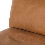 Close-up showing plush tan leather cushion surface with gentle wrinkles at backrest and seat junction
