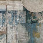 Close-up of rug corner showing texture contrast with nearby multicolored abstract patterned rugs