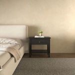 Katherine nightstand styled in neutral bedroom beside upholstered bed with books and plant on top