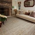 Sunrise rug in a living room with beige sofa and brick fireplace, showing scale and room context