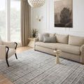 Modern rug laid flat in a bright living room styled with beige sofa and neutral decor