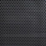 Macro detail of evenly spaced circular perforations on gunmetal iron door