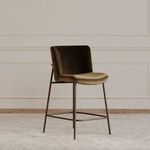 Stool styled in beige room with paneled walls and wood floor on light area rug