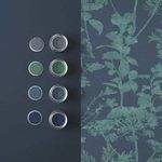 Wallpaper beside paint cans and color samples in shades of blue and green