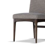Close-up of tapered dark wood front leg and seat edge on Abida Alcala Nickel Dining Chair