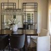 Dining room interior showing rug under table with velvet chairs, large mirrors, and soft natural light