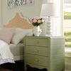 Jesse Lamp styled on green three-drawer nightstand beside bed with pastel pink pillows and floral wall art