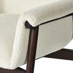 Armrest showing rounded padding over dark wooden frame with upholstery seam