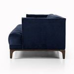 Angled view showing low silhouette and clean, sharp edges of navy velvet sofa
