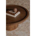 Close-up of tray top holding books and decorative ball on round oak coffee table