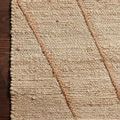 Close-up of rug corner on dark hardwood floor highlighting braided texture and natural fiber weave