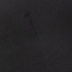 Close-up detail of matte black ceramic plate surface highlighting fine texture and color depth