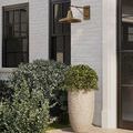 Mariner Wall Sconce lighting outdoor entryway with white brick and black window frame backdrop