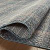 Folded rug showing backing and flatweave texture with blue edge binding