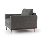 Side angle showing the chair’s profile, armrest thickness, and tufted back cushion depth