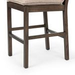 Close-up of upholstery seam where beige cushion meets almond wood frame on Wilmington Stool