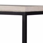 Close-up corner showing junction of light stone top and matte black metal frame